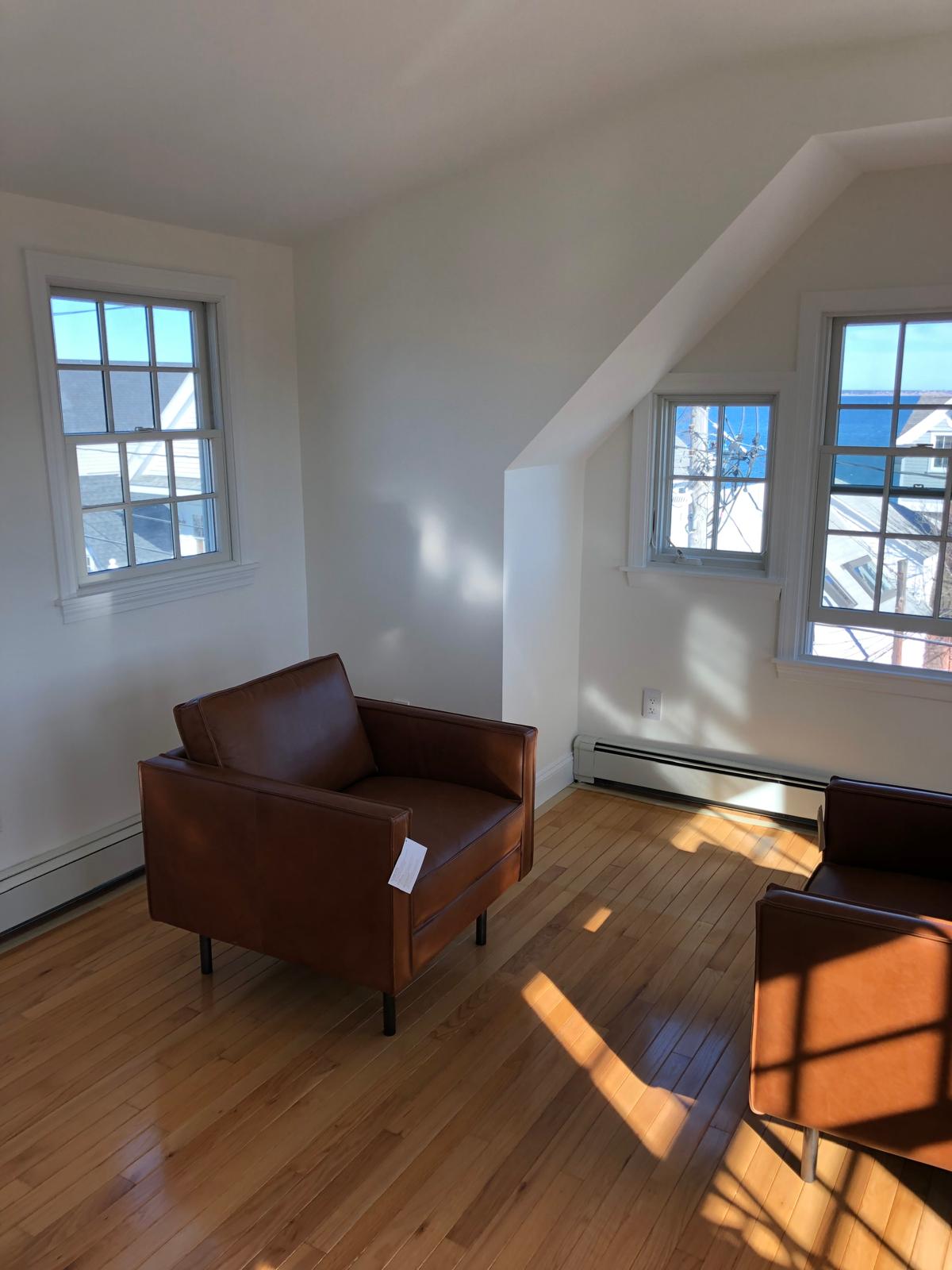 Empty room with refinished wood floors and fresh paint