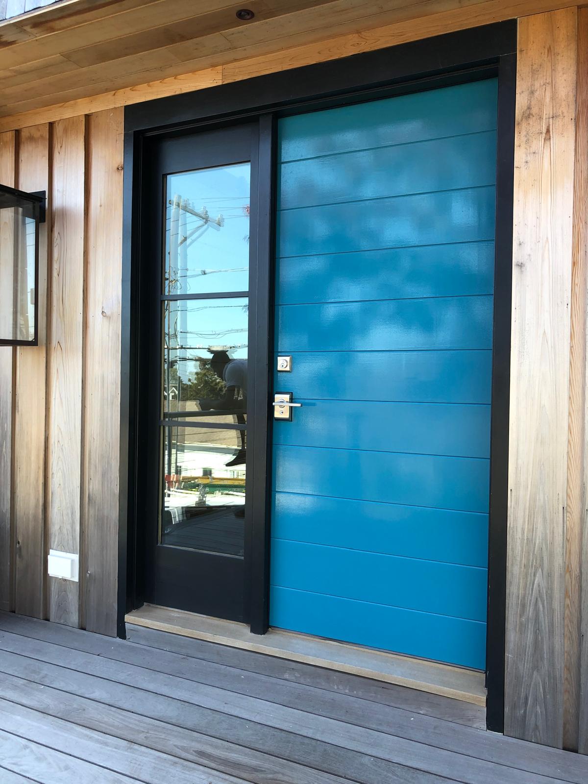 Bright blue front door on wood-sided home