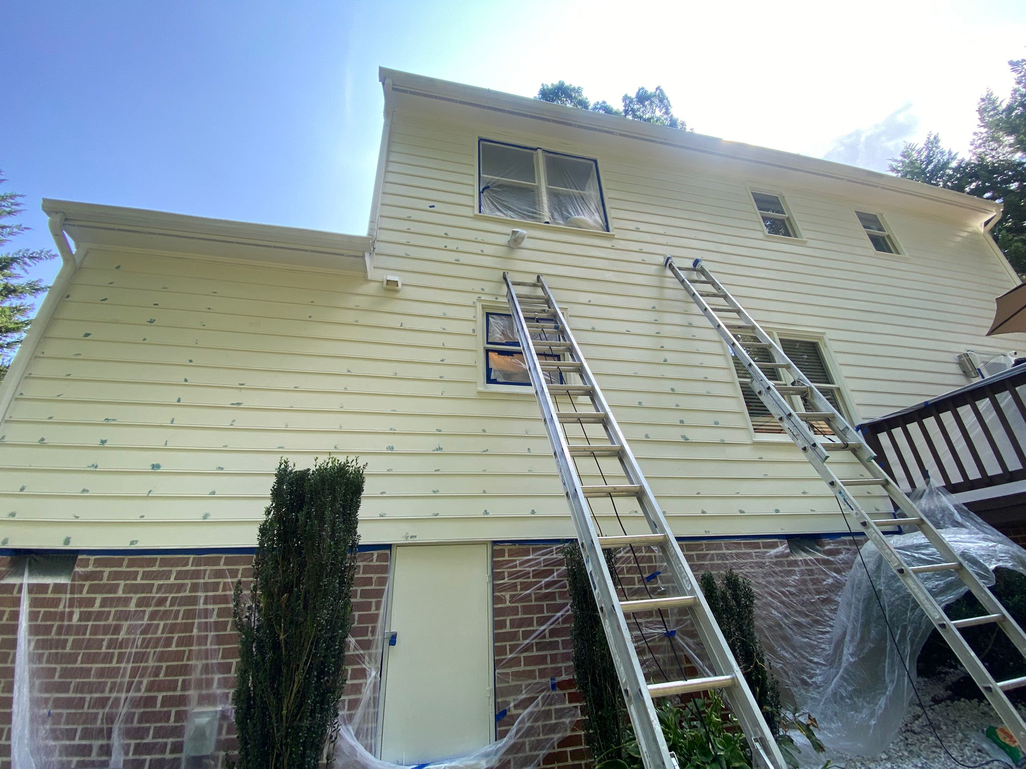 Exterior siding repaint with ladders in place
