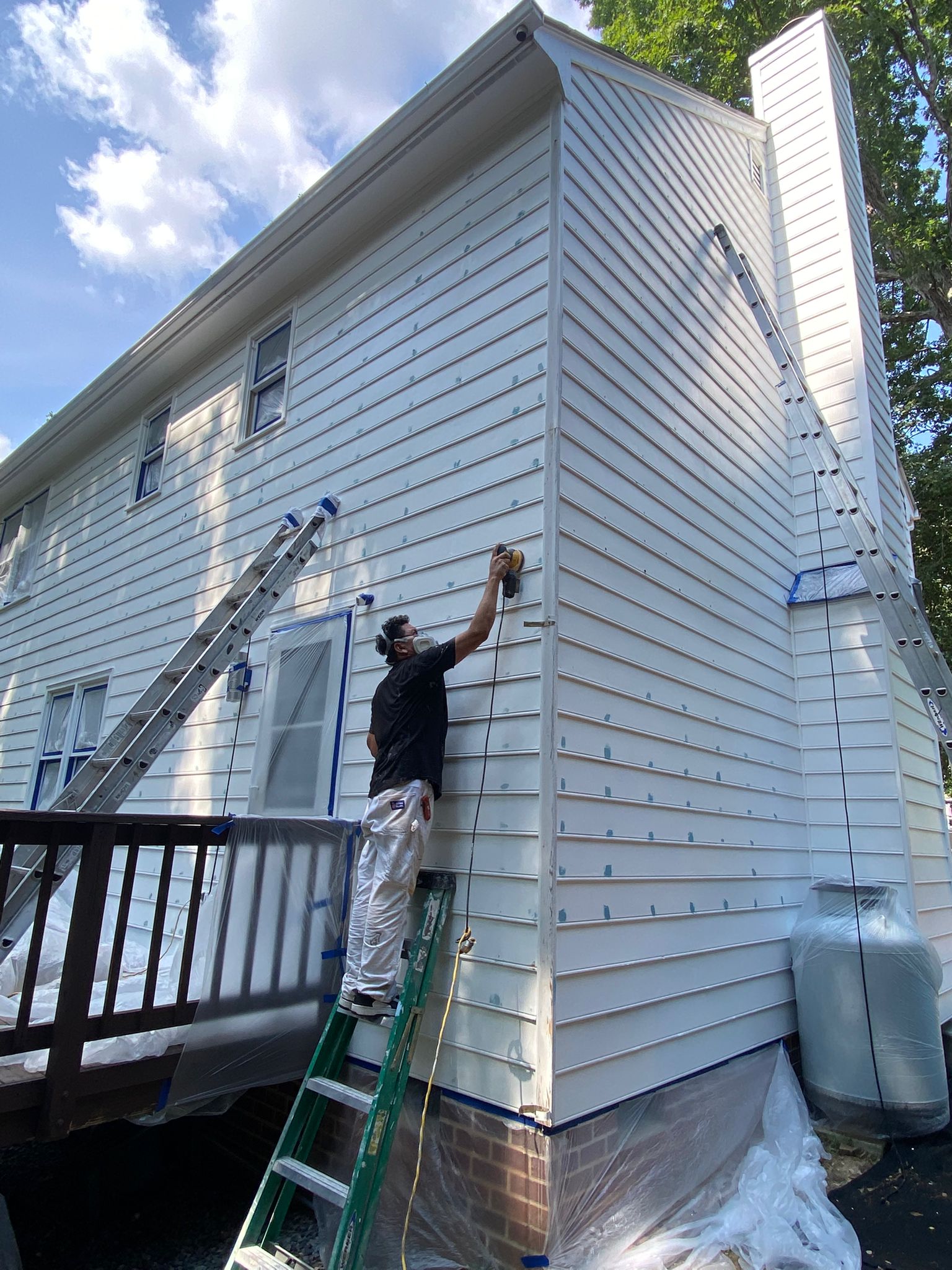 RG Pro Painters crew painting exterior siding from ladders