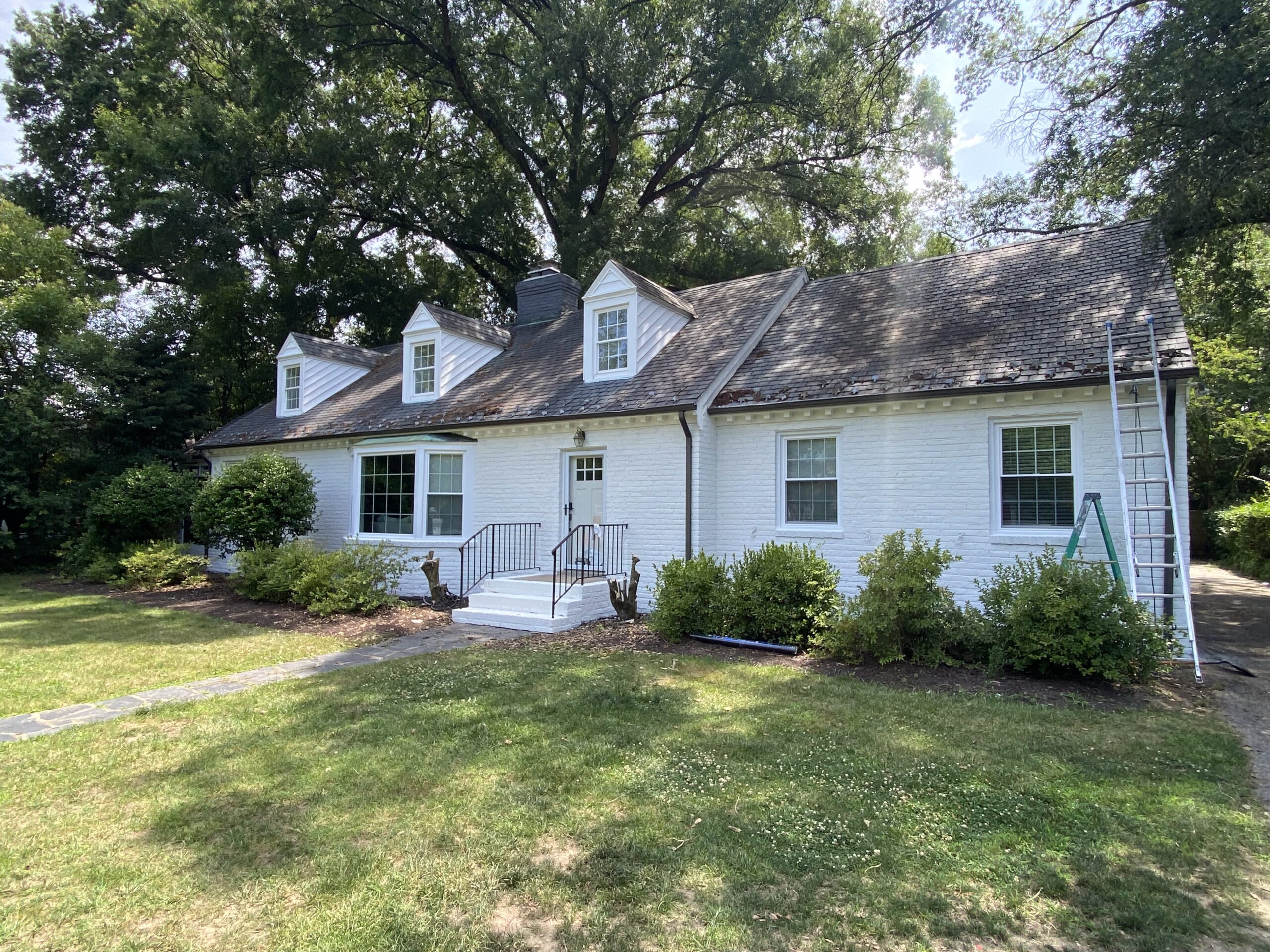 White painted cottage with landscaped yard