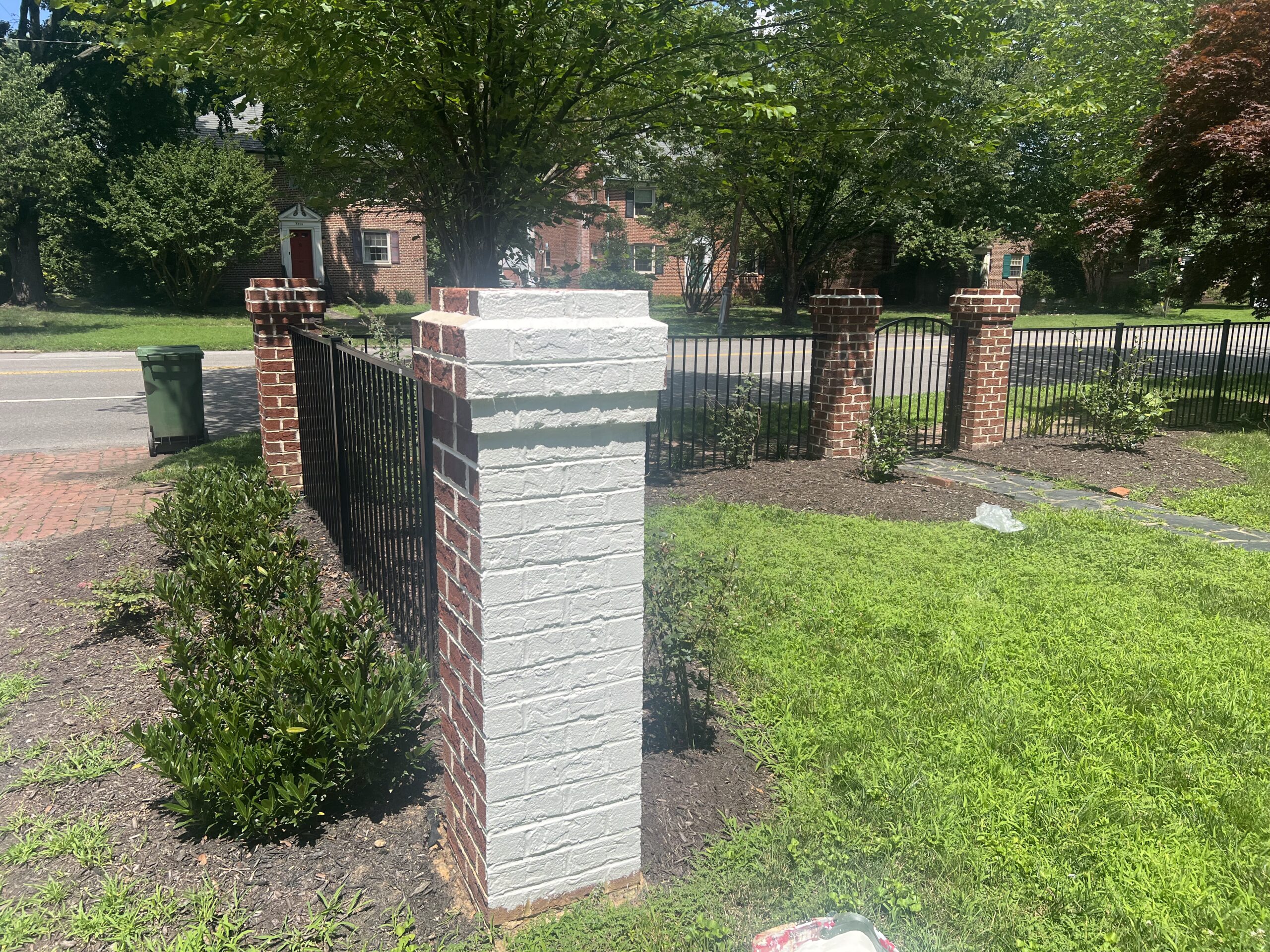 Painted brick pillar and iron fence