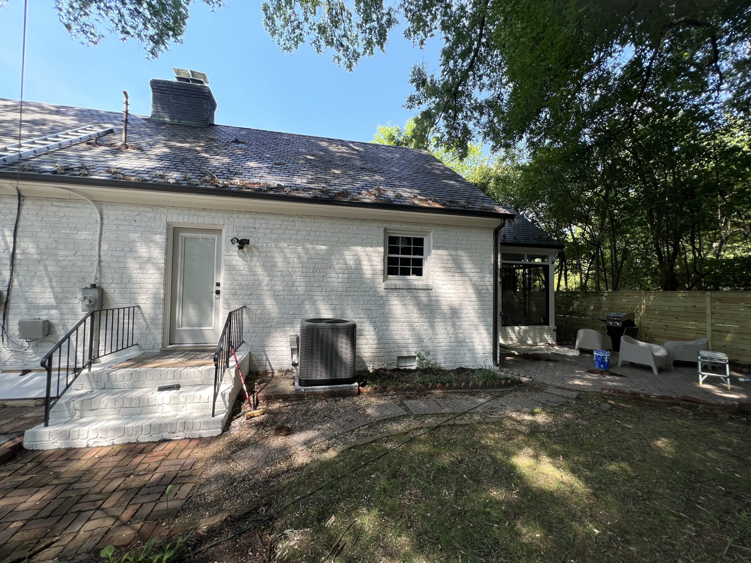 White brick home rear exterior and patio