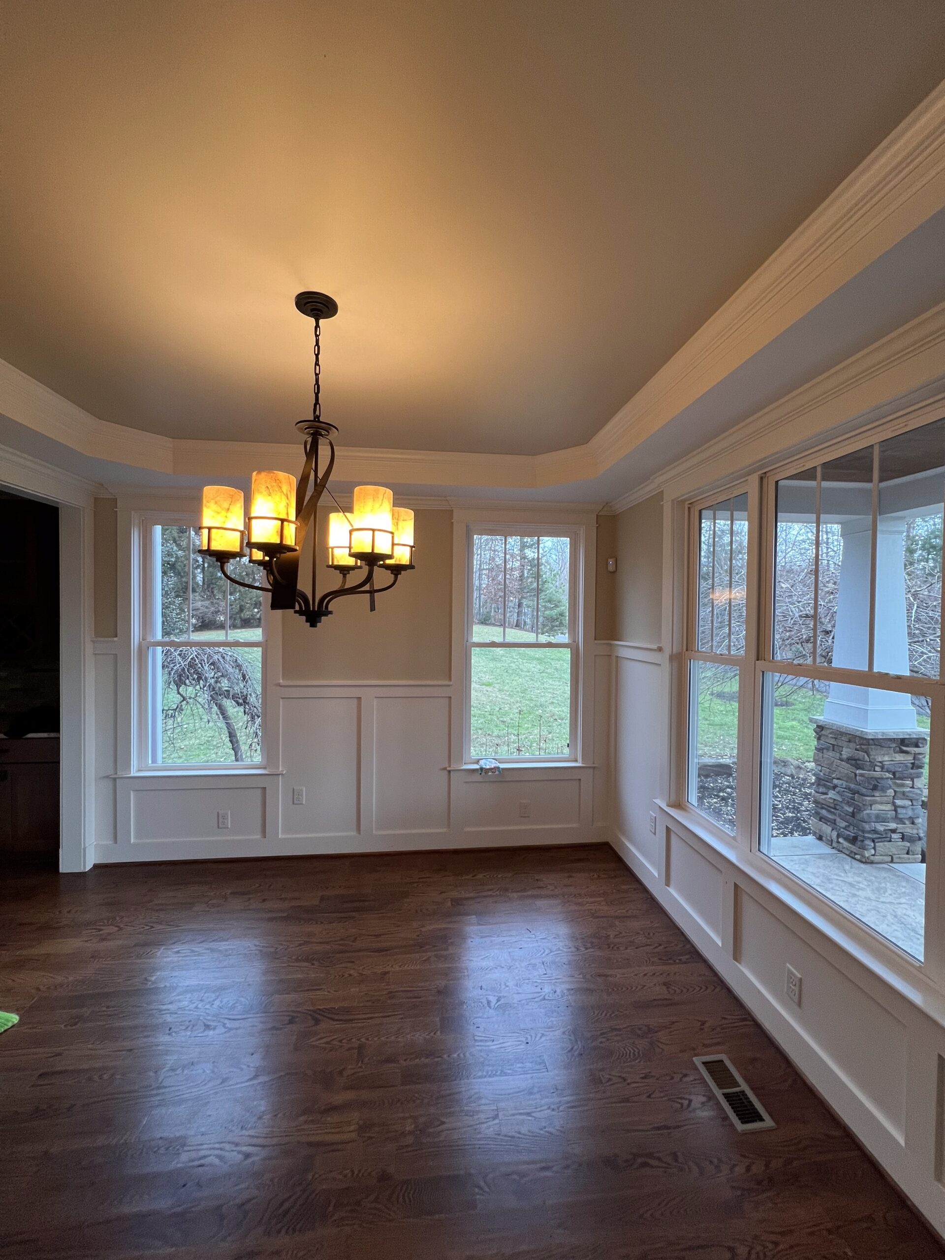 Sunroom with chandelier and painted wainscoting